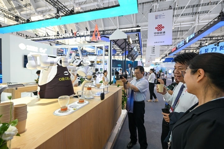 6月20日，與會者品嘗機器人沖調(diào)出的咖啡。新華社記者 孫凡越 攝