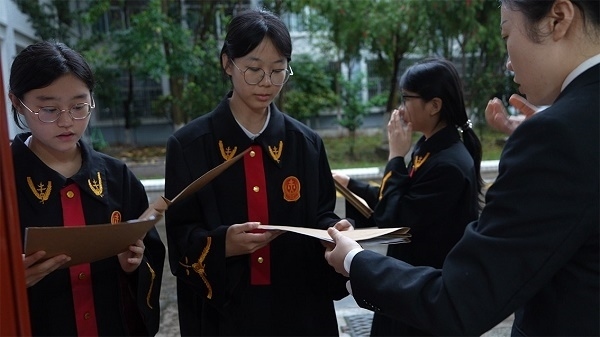 圖①：武平法院干警向?qū)W生分發(fā)道具卷宗。