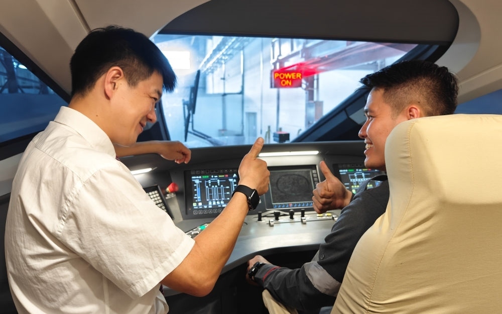 2023年8月25日，在印度尼西亞萬(wàn)隆的雅萬(wàn)高鐵德卡魯爾動(dòng)車(chē)所內(nèi)，中國(guó)師傅穆振（左）向印尼火車(chē)司機(jī)塞蒂亞萬(wàn)講解動(dòng)車(chē)組出庫(kù)前的上電作業(yè)。新華社記者 徐欽 攝