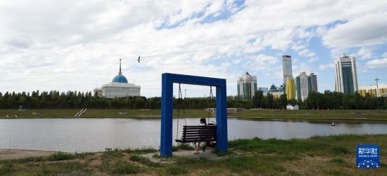 6月30日，一名女子在哈薩克斯坦首都阿斯塔納伊希姆河畔休息。新華社記者 王建華 攝