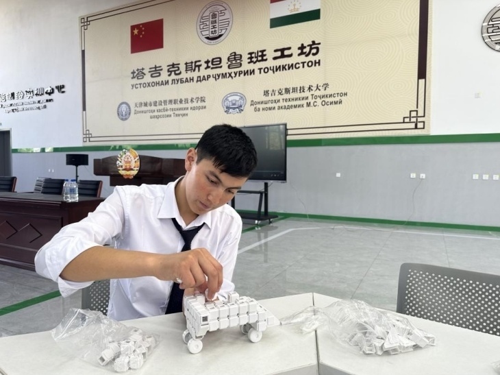 在塔吉克斯坦魯班工坊內(nèi)，學(xué)員正在操作能力源創(chuàng)新套件。本報(bào)記者 屈佩 攝