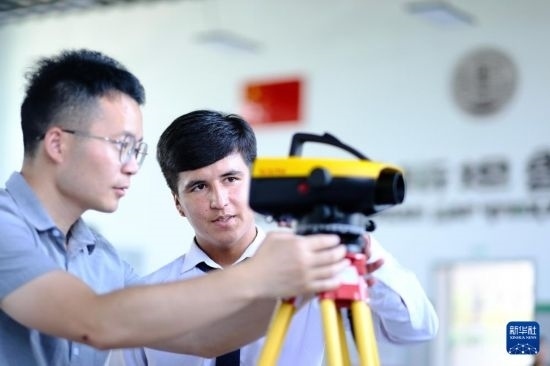 6月14日，在塔吉克斯坦首都杜尚別的魯班工坊，來自天津城市建設(shè)管理職業(yè)技術(shù)學(xué)院的老師（左）指導(dǎo)學(xué)生。新華社記者 鄭開君 攝