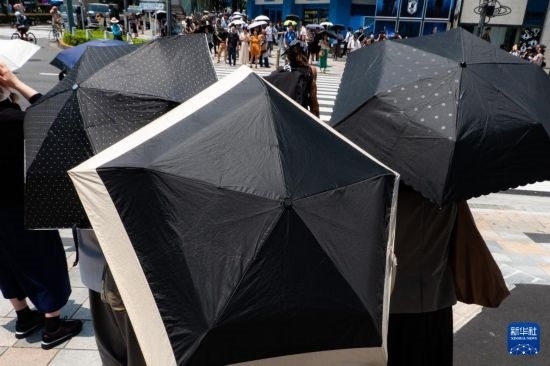 7月4日，人們?cè)谌毡緰|京原宿的街道上等待紅綠燈。新華社記者 張笑宇 攝