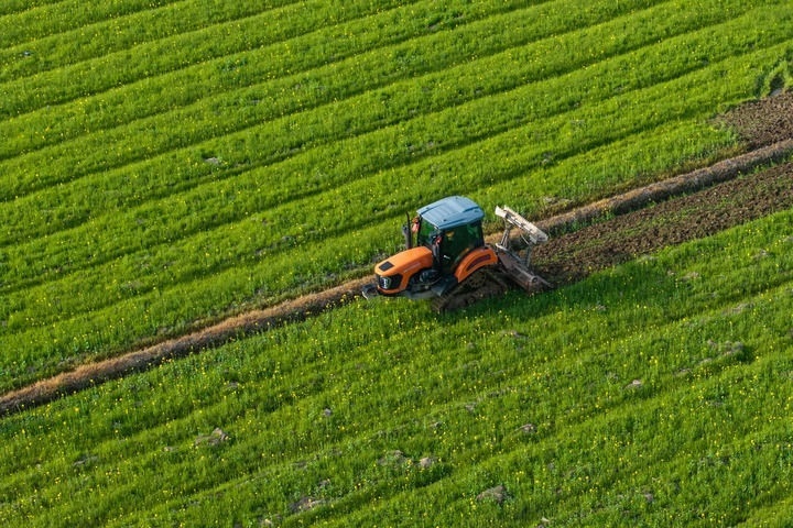 2024年3月19日，在湖南省常德市鼎城區(qū)謝家鋪鎮(zhèn)港中坪村，村民駕駛農(nóng)機(jī)翻耕田地（無(wú)人機(jī)照片）。新華社記者 陳思汗 攝