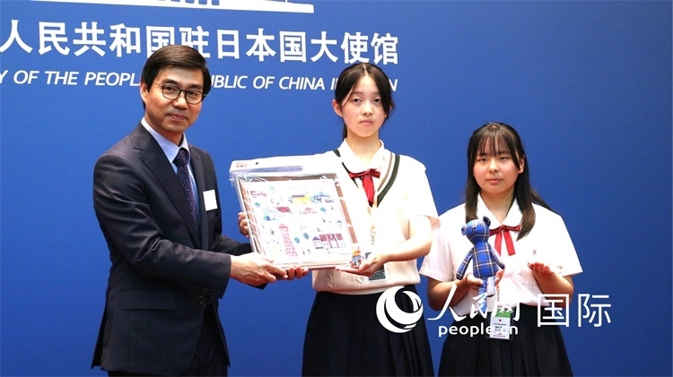 日本小大使向中國駐日本大使館臨時代辦施泳贈送當(dāng)?shù)靥厣Y品。人民網(wǎng) 許可攝