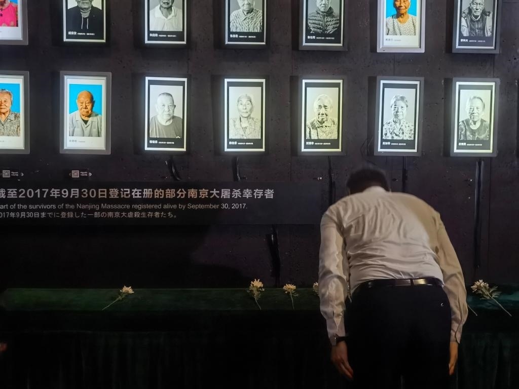 7月18日，人們向離世的南京大屠殺幸存者獻花、鞠躬。新華社記者邱冰清 攝