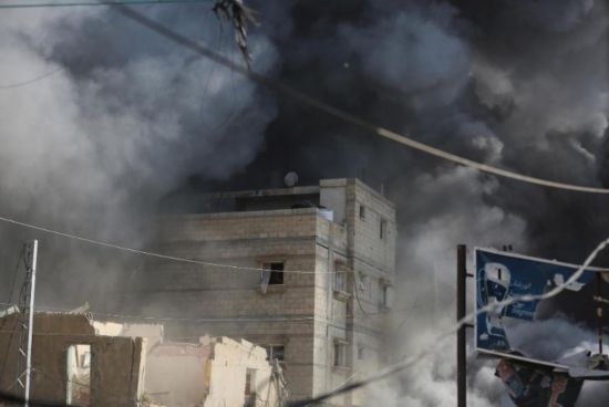 7月21日，在加沙地帶中部的努賽賴特難民營，遭以軍空襲的建筑冒出滾滾濃煙。新華社發(fā)（馬爾萬·達烏德攝）