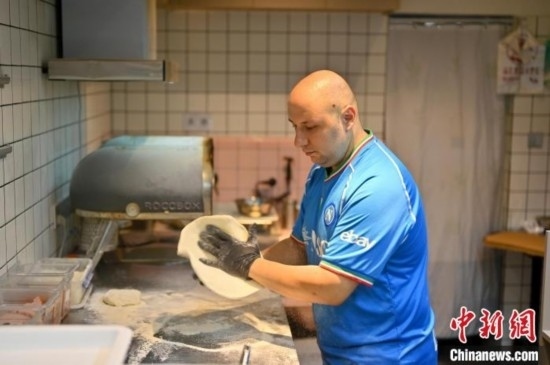 近日，韋榮耀在自家披薩小店內(nèi)忙活。俞靖 攝