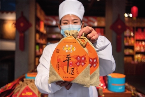 在位于山西省晉中市平遙縣的平遙古城南大街的一家平遙牛肉店內(nèi)，工作人員展示一款牛肉產(chǎn)品（資料照片）楊晨光攝 / 本刊