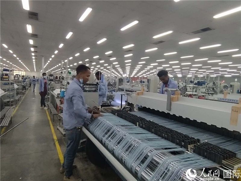 無錫金茂埃塞面料廠車間內(nèi)，當(dāng)?shù)毓と苏谝唤z不茍地作業(yè)。人民網(wǎng)記者 黃培昭攝