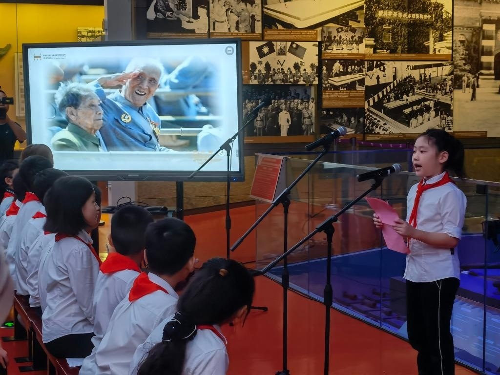 南京市科睿小學(xué)二年級學(xué)生章若初為大家講述抗戰(zhàn)老兵手印的故事。 新華社記者 邱冰清 攝