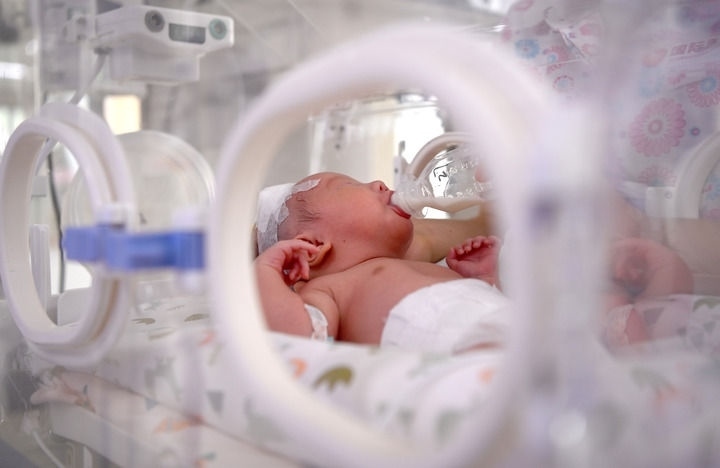 2024年6月1日，在西安國際醫(yī)學(xué)中心醫(yī)院新生兒科病房，護(hù)士為新生兒喂奶。 新華社記者 劉瀟 攝