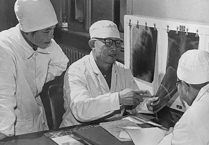 1980年1月16日，中日友好醫(yī)院首任院長辛育齡（中）在內(nèi)蒙古結(jié)核病院與胸外科醫(yī)師討論病例（翻拍照片）。 新華社發(fā)