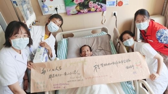 7月26日，海淀醫(yī)院安寧療護(hù)科醫(yī)護(hù)團(tuán)隊(duì)為朱銳送來(lái)一條寫滿祝福的橫幅。（受訪者供圖）