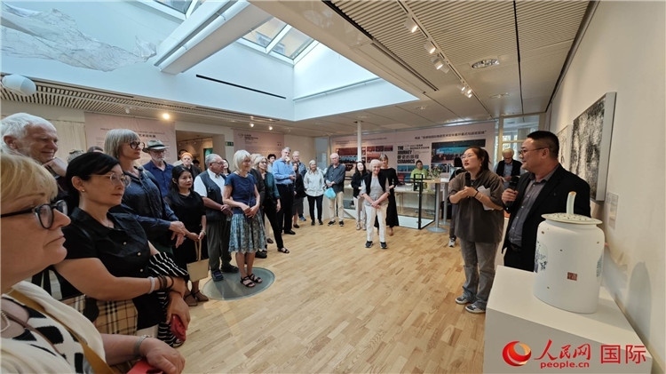 參展人、景德鎮(zhèn)陶瓷大學(xué)美術(shù)學(xué)院副院長(zhǎng)邵長(zhǎng)宗（右一）向來賓介紹參展作品。人民網(wǎng)記者 殷淼攝