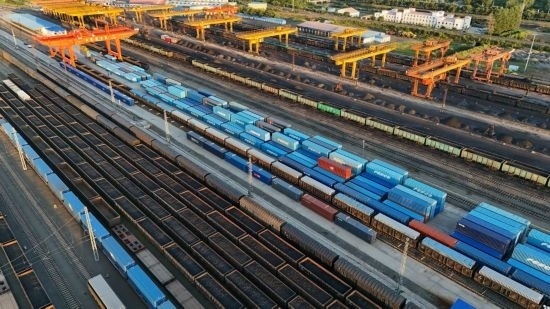 這是2024年8月14日在黑龍江綏芬河鐵路口岸集裝箱換裝場拍攝的集裝箱換裝作業(yè)現(xiàn)場（無人機(jī)照片）。今年前七個(gè)月，綏芬河鐵路口岸開行中歐班列573列，運(yùn)量達(dá)55246標(biāo)箱，同比分別增長23%和18%，班列數(shù)量持續(xù)保持高位運(yùn)行。