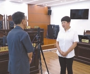 圖為全國人大代表玉明姬（右）詳細了解環(huán)境資源審判工作情況。劉思妤 攝