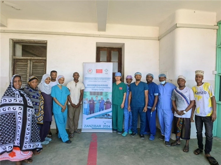 隊(duì)長(zhǎng)蔣國(guó)慶（右七）和手術(shù)醫(yī)生、部分患者合影。中國(guó)援桑醫(yī)療隊(duì)供圖