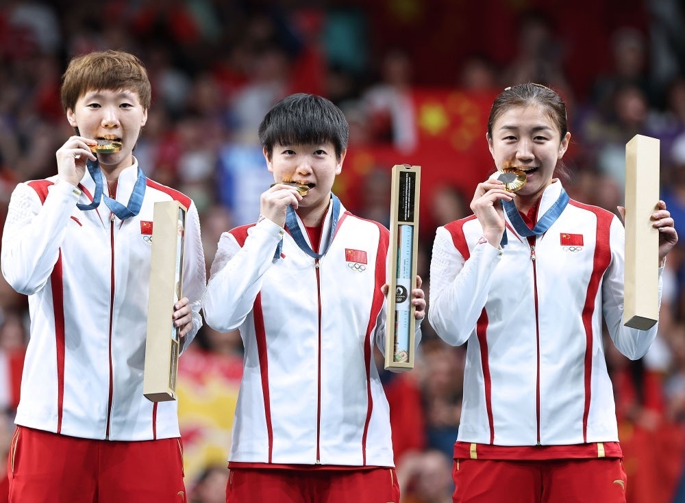 冠軍中國隊(duì)選手王曼昱、孫穎莎、陳夢(mèng)（從左至右）在巴黎奧運(yùn)會(huì)乒乓球女子團(tuán)體頒獎(jiǎng)儀式上（2024年8月10日攝）。新華社記者 王東震 攝
