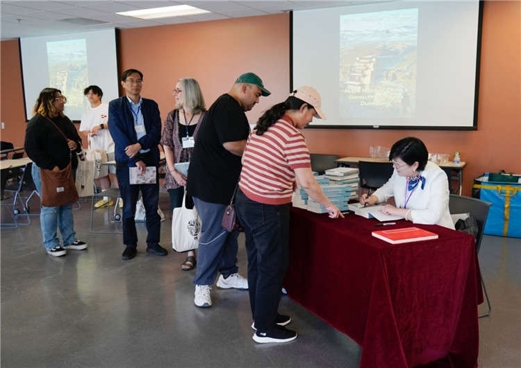 作者顧春芳在活動現(xiàn)場簽名贈書。羅先勇攝