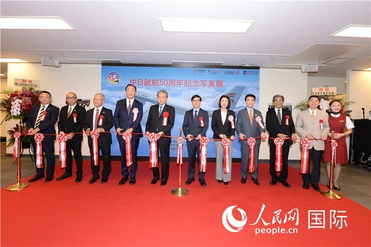 與會(huì)嘉賓共同為中日通航50周年紀(jì)念圖片展開(kāi)幕剪彩。馮學(xué)敏攝
