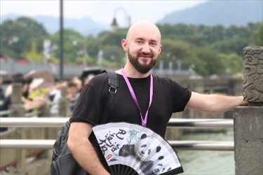 俄羅斯塔斯社執(zhí)行編輯葉夫根尼·扎多羅日內(nèi)在都江堰魚嘴拍照留念。（李佩藺 攝）