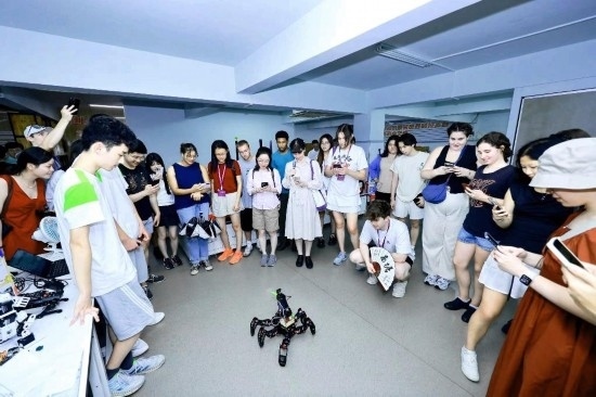 8月25日，中外青年在浙江杭州觀看機(jī)器人表演。新華社發(fā)（清華大學(xué)供圖）