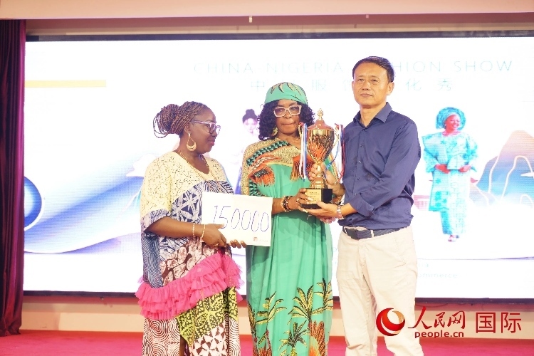 中國(guó)駐尼日利亞使館文化參贊兼中國(guó)文化中心主任李旭大（右）為最佳表現(xiàn)獎(jiǎng)?lì)C獎(jiǎng)（中）。人民網(wǎng)記者 姜宣攝