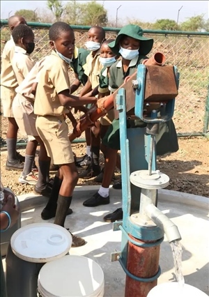 △2021年11月，在津巴布韋南馬塔貝萊蘭省省會(huì)關(guān)達(dá)的塞農(nóng)多小學(xué)，學(xué)生從中國(guó)援建水井里打水。