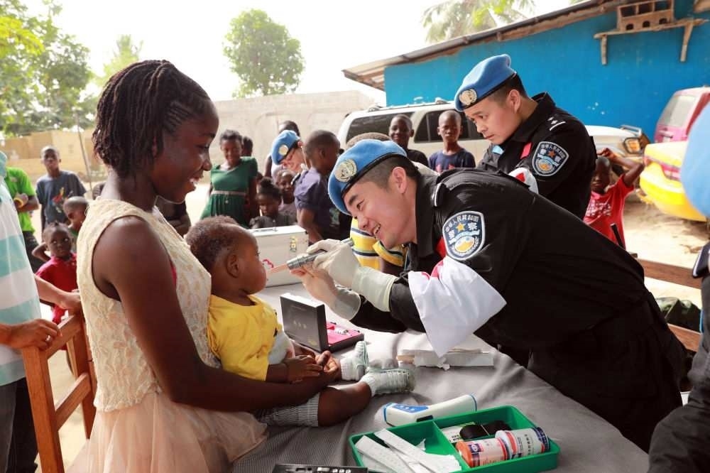 2017年12月28日，在利比里亞蒙羅維亞，中國(guó)維和警察防暴隊(duì)醫(yī)療人員為兒童做口腔檢查。