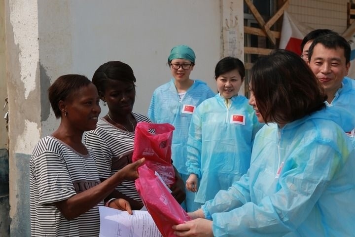 2015年4月4日，在位于塞拉利昂首都弗里敦市郊的中塞友好醫(yī)院埃博拉診療中心，中國第四批援塞醫(yī)療隊副隊長邵蔚（右前）向被治愈的埃博拉出血熱患者贈送禮物。新華社發(fā)（祖榮強 攝）