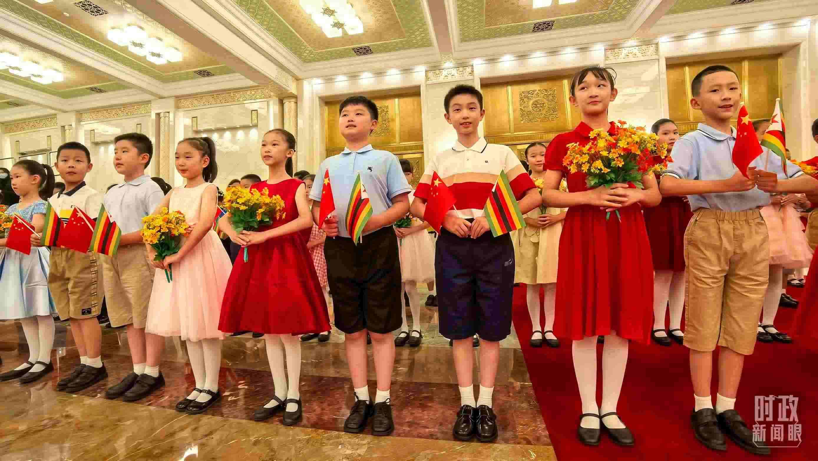 △現(xiàn)場歡迎津巴布韋總統(tǒng)訪華的青少年。（總臺央視記者鐘銳拍攝）