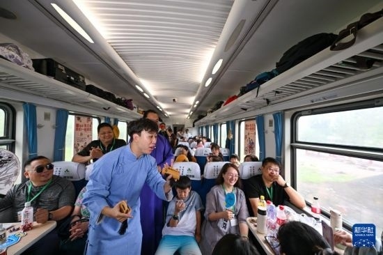 9月7日，相聲演員在S910列車上為旅客表演快板。