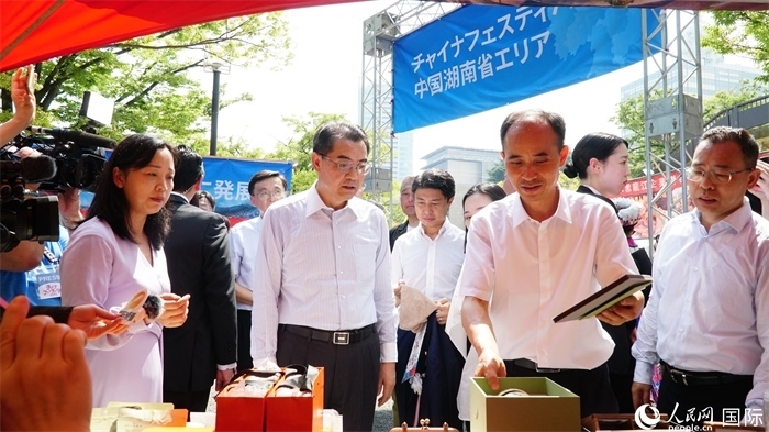 湖南展位工作人員向中國駐日本大使吳江浩介紹特色文創(chuàng)產(chǎn)品。人民網(wǎng) 蔣曉辰攝