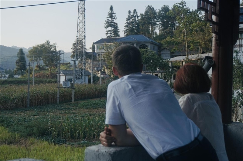 望得見山，看得見水，記得住鄉(xiāng)愁。每個人心中都有一個屬于自己的“花茂村”，在這方心田，走遍千山萬水，鄉(xiāng)音未改鬢毛衰。吉爾吉斯斯坦《比什凱克晚報》第一副總編輯妮娜·尼奇博洛娃與《中國與俄羅斯》雜志社社長奧列格·別列日內(nèi)赫攝在花茂村民居屋檐下并肩佇立，眺望山水，尋覓鄉(xiāng)愁。（李光裕攝）