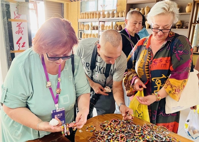 歐亞媒體考察團(tuán)成員在母氏陶藝館內(nèi)挑花了眼，色彩絢麗、質(zhì)地均勻的陶藝手串讓他們愛不釋手。“這里的東西都太實(shí)惠了！”塔吉克斯坦《索格特真理報》政論部主任娜塔利婭·多羅費(fèi)耶娃說?；宓奶厣a(chǎn)品物美價廉，讓考察團(tuán)成員為家人好友買到了心儀的禮物，也為此次以四川成都為起點(diǎn)，路經(jīng)南充、廣安至貴州遵義的考察行程畫上了圓滿句號。（張亞欣攝）