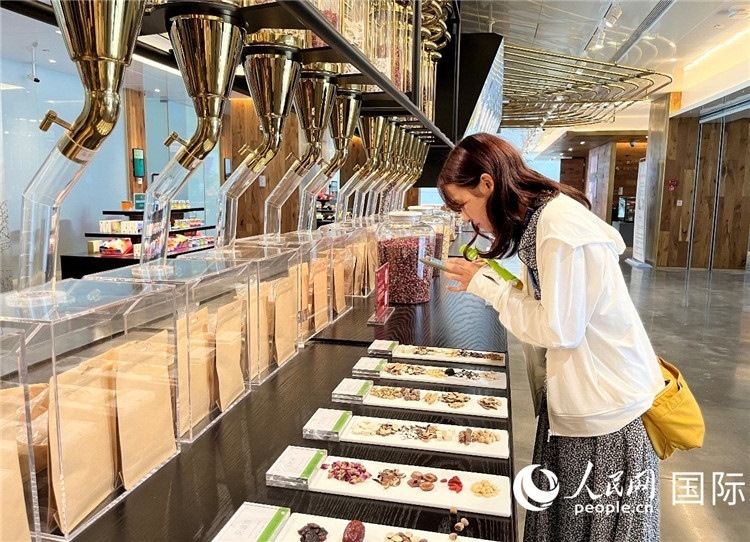 4. 代表團(tuán)團(tuán)員對(duì)新中式茶飲的食材充滿興趣。（人民網(wǎng)記者陳思 攝）