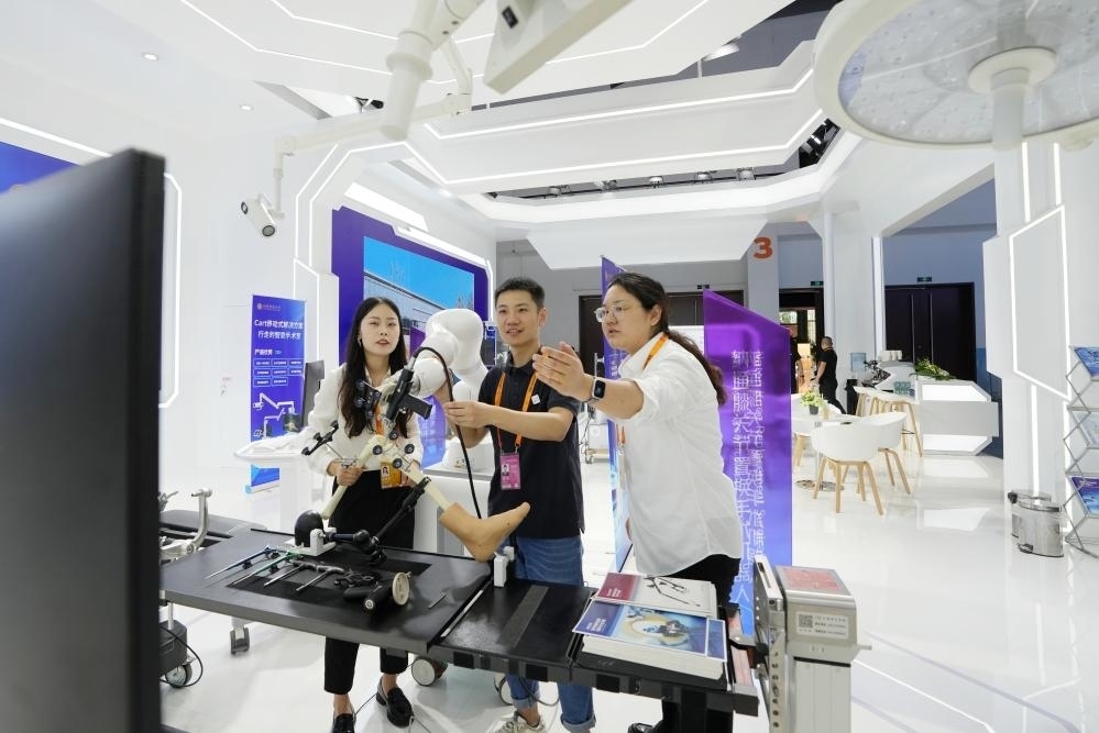 9月11日，一位媒體記者（中）在2024年服貿(mào)會(huì)國(guó)家會(huì)議中心會(huì)場(chǎng)體驗(yàn)北京納通科技集團(tuán)有限公司的膝關(guān)節(jié)置換手術(shù)機(jī)器人。新華社記者鞠煥宗 攝