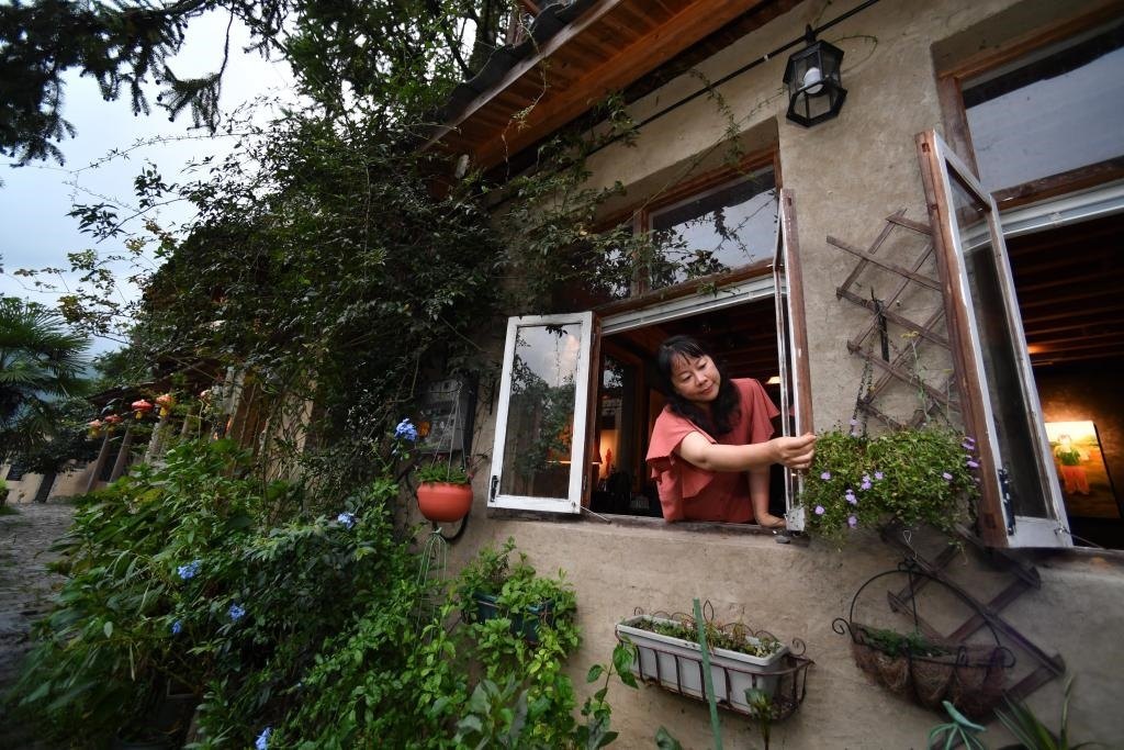 8月29日，在福建省屏南縣熙嶺鄉(xiāng)，龍?zhí)洞濉靶麓迕瘛泵泛暝诖蚶碜约航?jīng)營(yíng)的民宿外墻裝飾花盆。新華社記者姜克紅 攝