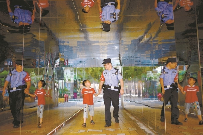 ?7月16日，重慶市公安局江北區(qū)分局一名民警在巡邏途中遇到一個(gè)獨(dú)自玩耍的小男孩，民警將其送回家。王洪平攝