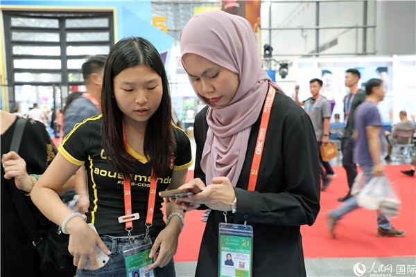 東博會現(xiàn)場，馬來西亞展商在同中方工作人員交談。人民網(wǎng)記者 趙益普攝