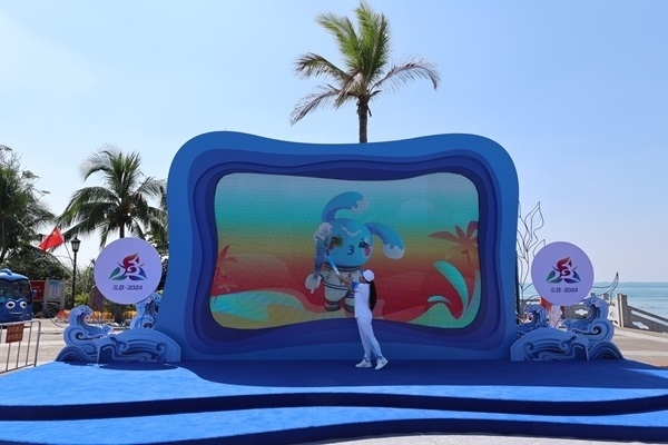 第12棒火炬手“點燃”現(xiàn)場大屏幕上運動會吉祥物“吉貝”手中的火炬。主辦方供圖