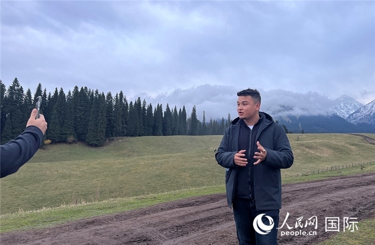 在庫爾德寧，吾買爾江被雪山美景震撼，即興錄制了短視頻作品。人民網(wǎng)記者曾書柔攝