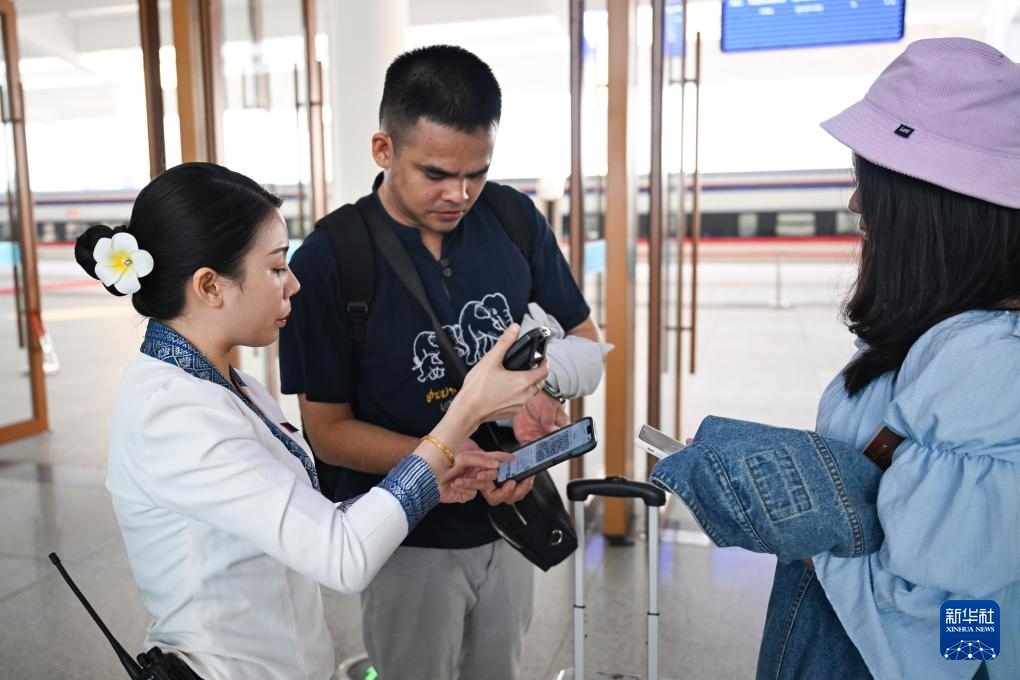 10月12日，在老撾萬象中老鐵路萬象站，工作人員檢驗乘客車票。新華社記者 程一恒 攝