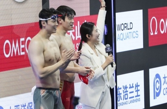  10月18日，汪順（左）和潘展樂在男子100米混合泳決賽后。新華社記者 方喆 攝