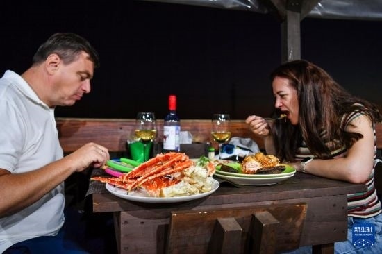 9月2日，食客們在俄羅斯符拉迪沃斯托克的一家餐館品嘗帝王蟹。新華社記者 曹陽 攝