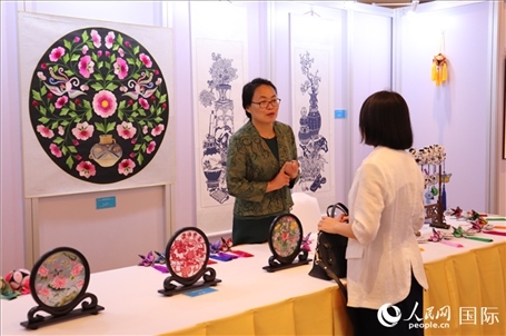 青海非遺文化傳承人向嘉賓介紹展品。人民網(wǎng)實(shí)習(xí)生姚欣可攝