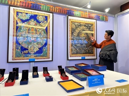 熱貢藝術(shù)國(guó)家級(jí)代表性傳承人夏吾角向嘉賓介紹作品。人民網(wǎng)記者 簡(jiǎn)承淵攝