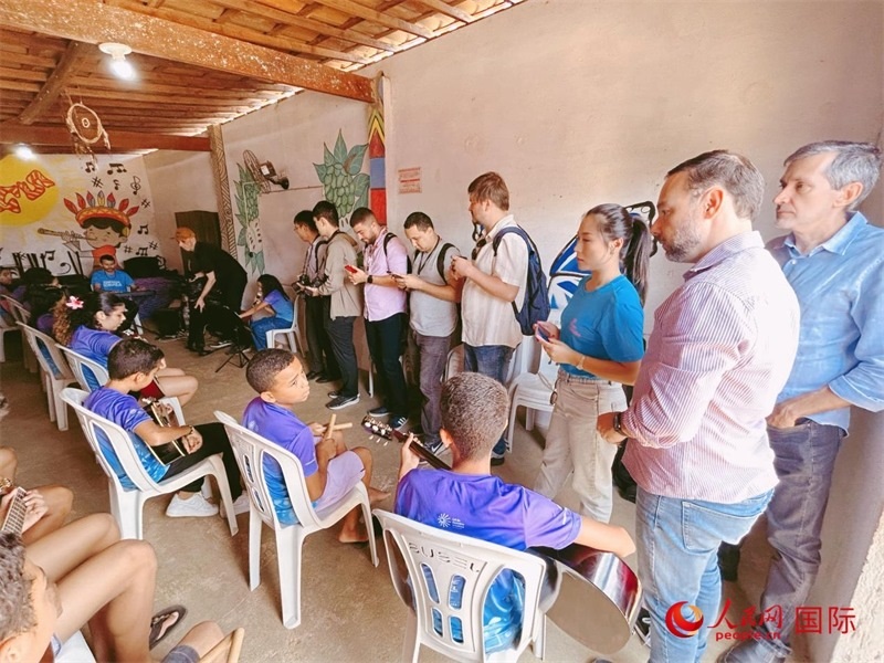  受益于中國企業(yè)的“青少年成長”項(xiàng)目，700多名當(dāng)?shù)厍嗌倌甑囊魳泛妥闱驂粝氩迳狭顺岚颉D為聯(lián)合采訪團(tuán)正在采訪參加音樂培訓(xùn)的孩子們。 人民網(wǎng)記者 陳一鳴攝