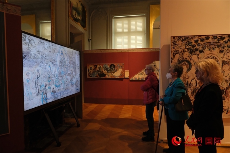 觀眾在展臺(tái)觀看錄像講解。人民網(wǎng)記者 尚凱元攝